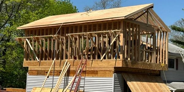 Wooden framework of a house under construction on top of an existing structure.