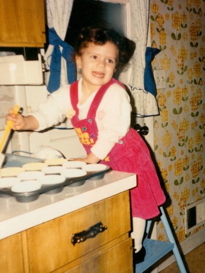 Child baking in a kitchen with retro decor.