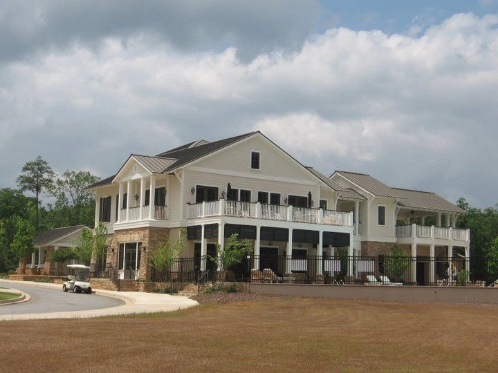 Large modern clubhouse with wrap-around balconies and a golf cart.