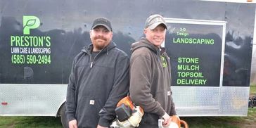 Aaron and Jim Preston standing in front of company vehicle.