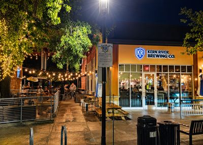 Nighttime scene at Kern River Brewing Co. with outdoor seating and string lights.