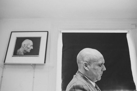 Portrait of Carl Williams in front of portrait of William S. Burroughs by Robert Mapplethorpe.