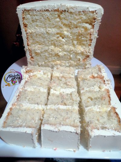 Sliced vanilla cake with white frosting on a plate.