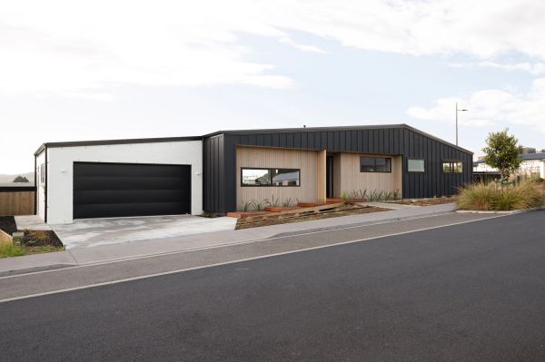 Modern single-story house with black and wood exterior.
