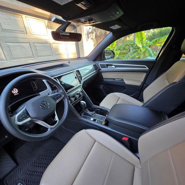 Interior view of a Volkswagen Atlas with beige leather seats and modern dashboard.