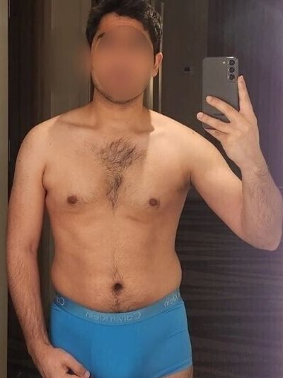 Man taking a mirror selfie in blue boxer briefs.