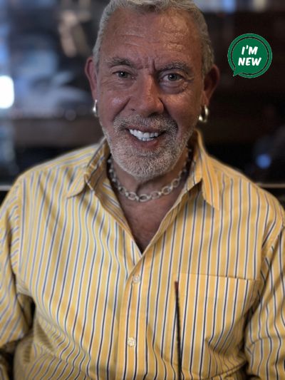 Smiling elderly man with silver hair and beard.