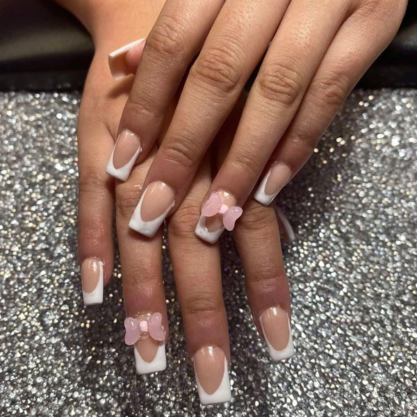 Nails with French tips and pink bow decorations.