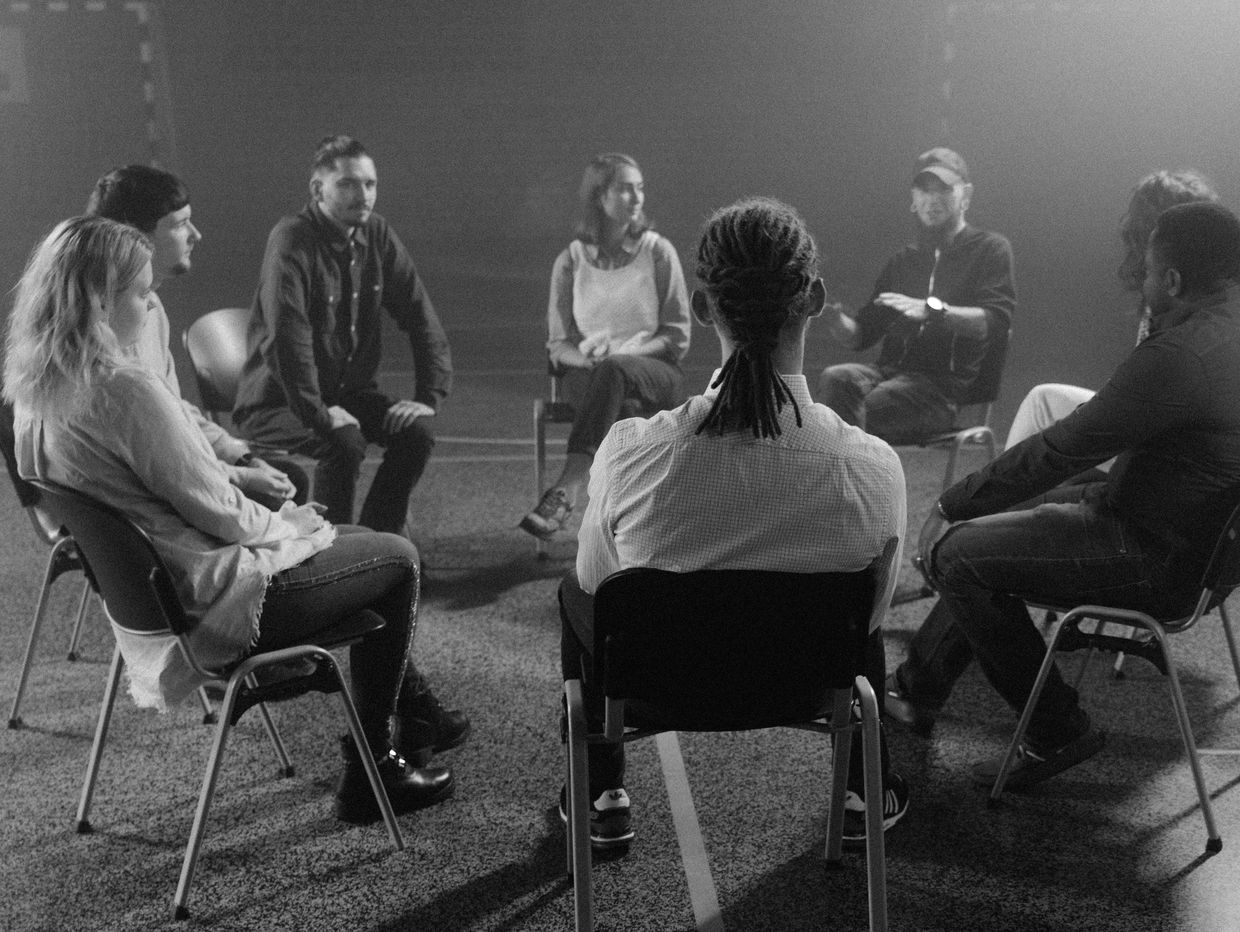 A group therapy session with participants sitting in a circle.