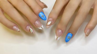 Elegant nails with blue, white, gold, and shell designs.