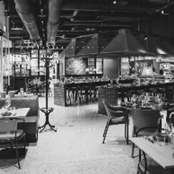 Modern restaurant interior with tables and chairs.