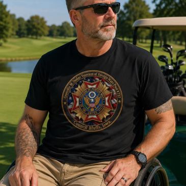 Man in a wheelchair wearing a veterans t-shirt at a golf course.