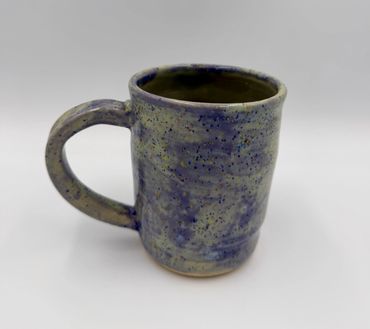 Speckled ceramic mug with a blue and beige glaze.