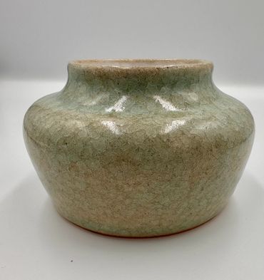 A round ceramic vase with a greenish crackled glaze.