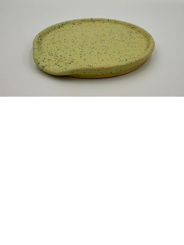 Round speckled ceramic plate with a small spout on the edge.