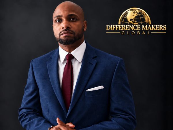 Man in blue suit posing confidently with 'Difference Makers Global' logo.