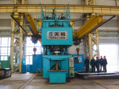 Large industrial forging machine with workers.