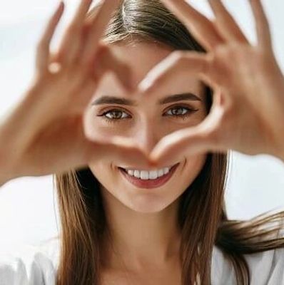 Woman making a heart shape with her hands.