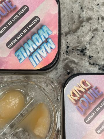 Cannabis live resin containers labeled Maui Wowie and King Louie on a marble surface.