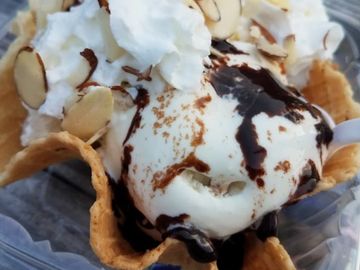 Homemade vanilla ice cream with hot fudge sliced almonds and whipped cream.  Almond joy Sundae 