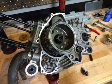 Disassembled engine part on a workbench with tools around.