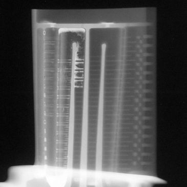 X-ray image of a mechanical or electronic component with cylindrical structures.