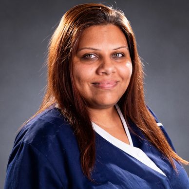 Smiling woman in a blue and white uniform.