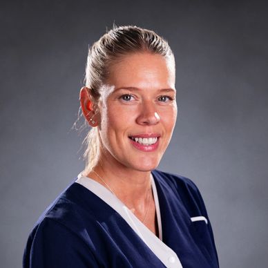 Smiling woman with blonde hair in a navy blue top.