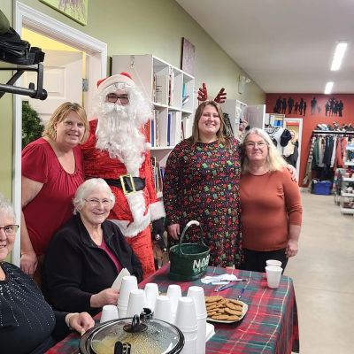 Group enjoying a festive holiday gathering with Santa and treats.