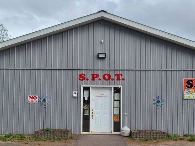 Gray building with S.P.O.T. sign above the door.