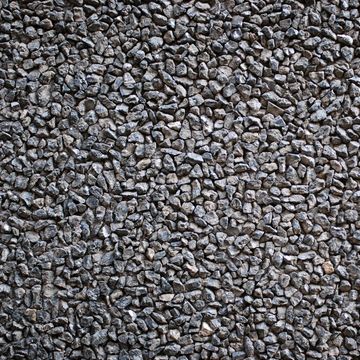 Close-up of a textured surface made of small gray stones tightly packed together.