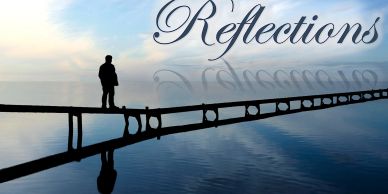 A person stands on a pier reflecting on calm water under a serene sky.