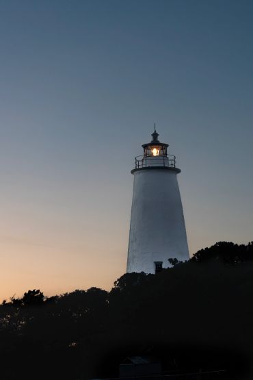 Lighthouse glowing at dusk.