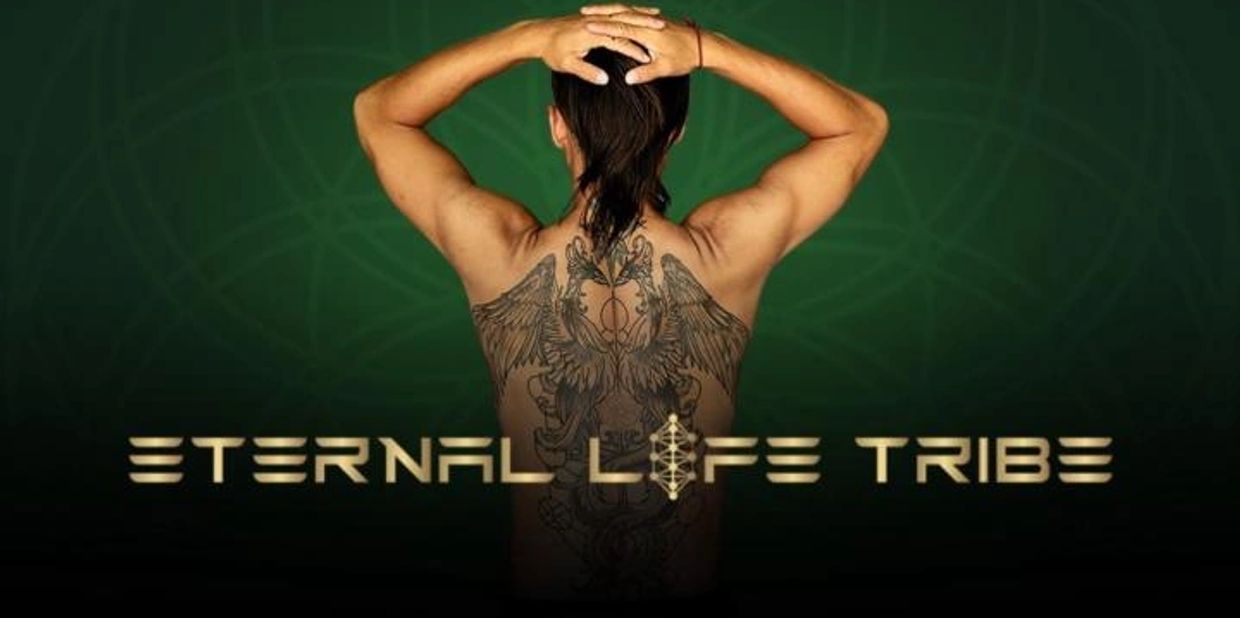 Person with intricate back tattoo and text 'Eternal Life Tribe' below.