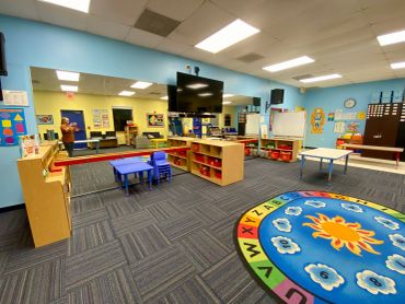 Empty colorful preschool classroom with learning areas.