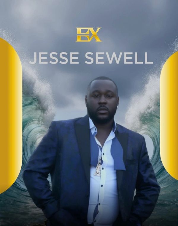 Jesse Sewell in a formal suit with a stormy ocean background.