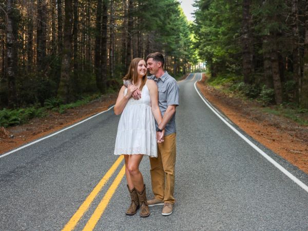 Couple posing on a forest road.
