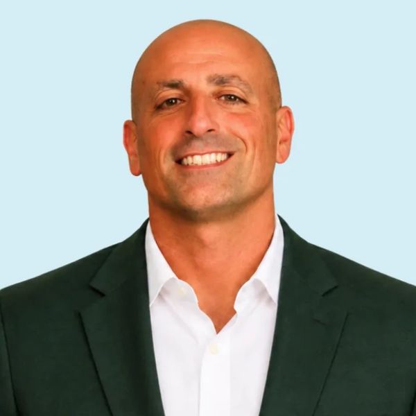 Smiling bald man in suit jacket and white shirt.