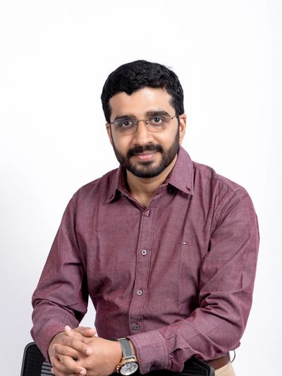 Man with glasses in a maroon shirt.