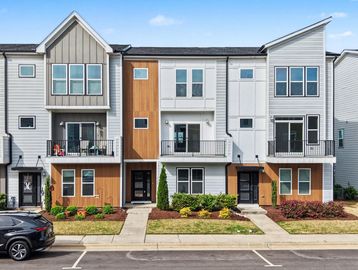 Modern townhouses with mixed wood and white siding and small balconies.