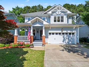 Blue and white two-story house with a front porch and American flag.