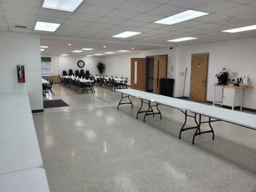 A large, clean meeting room with tables and chairs arranged for an event.
