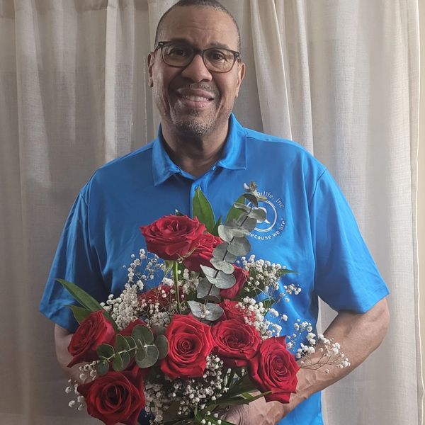 Board Member Paul Williams posing with aFreedom Rose bouquet.