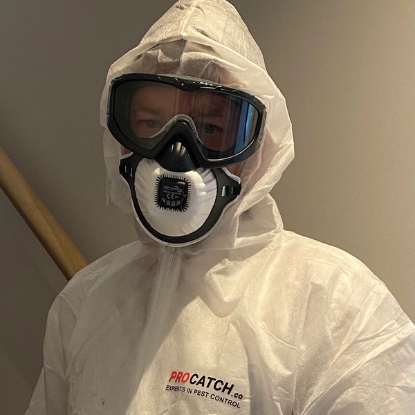 A technician in a white suit with goggles