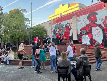 Live band playing music on an outdoor patio with people dancing and enjoying the atmosphere.