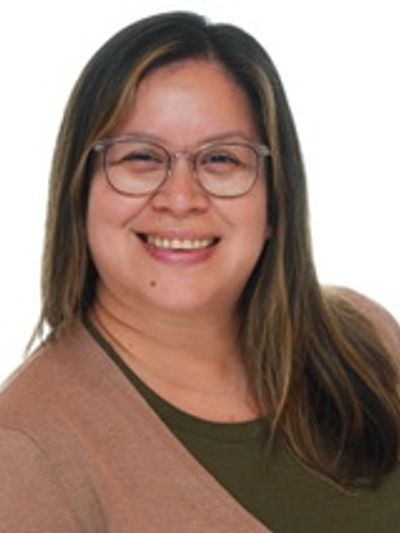 Smiling woman with glasses and long hair.