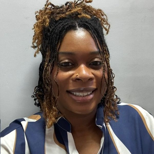 Woman with braided hair smiling at the camera.