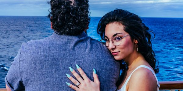 Woman looking into camera and man looking towards water in a photo. Photo taken by Karl Alan Media.