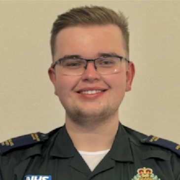 Young man in medical uniform with NHS badge.