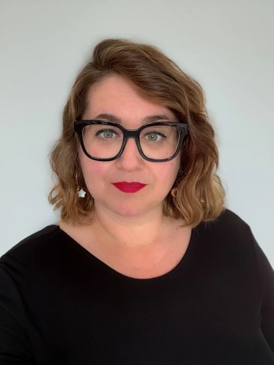 Photo portrait d'une jeune femme aux yeux verts, cheveux roux ondulés, coupe carré, portant des lune